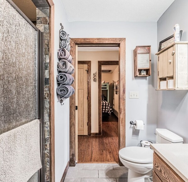 A bathroom with a toilet, a sink, and a shower area.