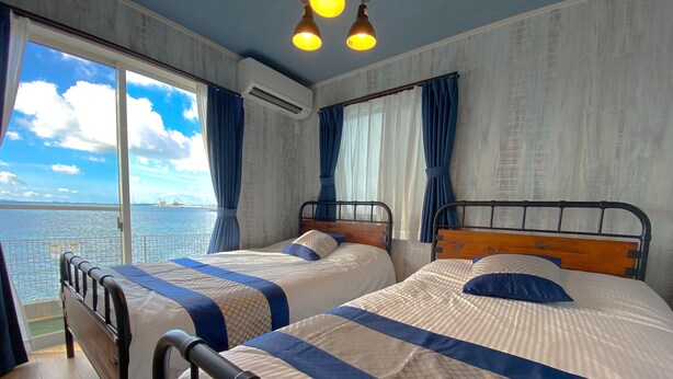 A room with two beds, a large window with curtains, an air conditioning unit, and a view of the sea. - Private Villa Kin1 with ocean view and BBQ (Kin)