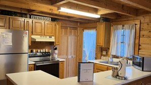 A cabin-style kitchen with wooden cabinets, a stainless steel refrigerator, a stove, and a microwave. - A Little Bit of Heaven. Hot tub, Pool Table, Pigeon Forge Cabin (Sevierville)
