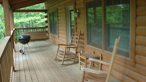 A wooden porch with a grill and two rocking chairs. - A Little Bit of Heaven. Hot tub, Pool Table, Pigeon Forge Cabin (Sevierville)
