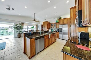 Una cocina moderna con armarios de madera, electrodomésticos de acero inoxidable y encimera de granito.
