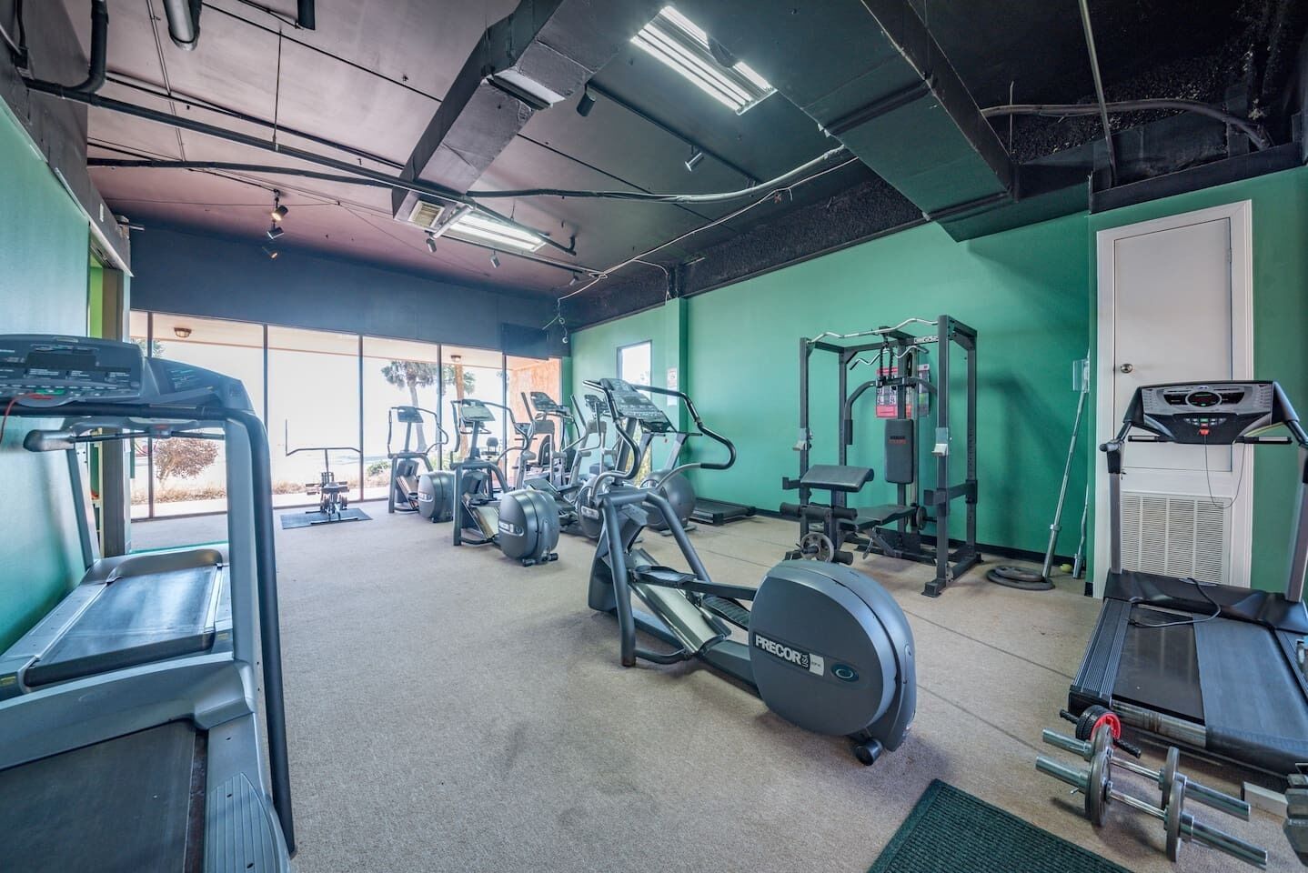 A gym with treadmills, elliptical machines, and weight equipment.