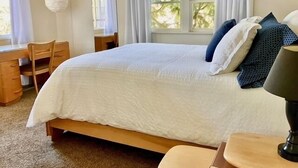 Un dormitorio con cama, escritorio y silla.