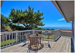 Enjoy a serene view from this deck with a round table and two chairs.