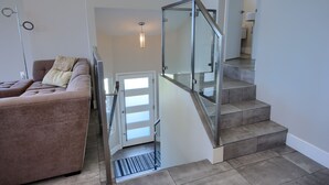 Een modern interieur met een trap, een bank en een hanglamp.