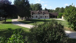 A large, two-story building with a traditional architectural style, surrounded by a well-maintained lawn and trees.