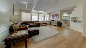 A spacious living room with a sectional sofa, a coffee table, and a TV mounted on the wall. - Why Stay in the confinement of a hotel, when Ucan stay in this Las Vegas Oasis. (Las Vegas)