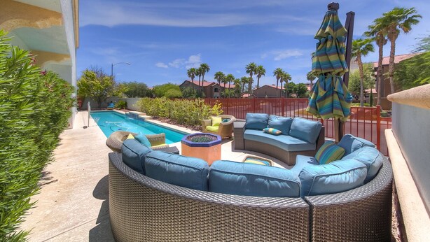 A patio with wicker furniture, a pool, and palm trees. - Why Stay in the confinement of a hotel, when Ucan stay in this Las Vegas Oasis. (Las Vegas)