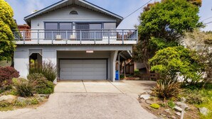 A two-story house with a garage, a balcony, and a well-maintained garden. - Snug Harbor: 3  BR, 2  BA House in CAMBRIA, Sleeps 6 (CAMBRIA)
