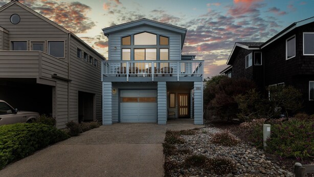 A two-story house with a garage, a balcony, and a driveway leading to the entrance. - Sea'Scape : 2  BR, 2  BA House in Cambria, Sleeps 4 (Cambria)