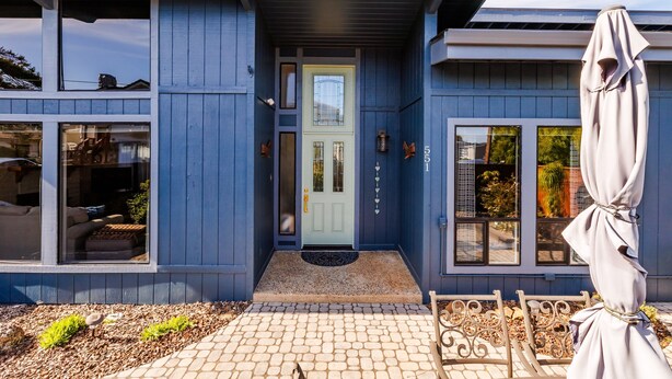A modern house with a blue exterior, a front door, and a small porch area.