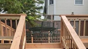 Un escalier en bois avec une rampe, menant à une terrasse.