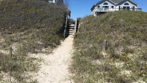 A sandy path leading to a house with a white exterior and a balcony. - Great Ocean View! Quiet Cul-de-sac, 4 minute walk to Beach, Waterpark, Shopping  (Emerald Isle)
