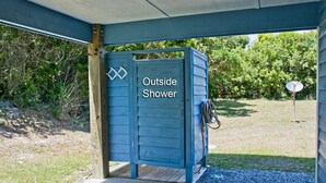 A blue outdoor shower structure with a sign indicating its purpose. - Great Ocean View! Quiet Cul-de-sac, 4 minute walk to Beach, Waterpark, Shopping  (Emerald Isle)