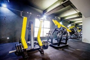A gym with weightlifting equipment and a mirrored wall. - Kingwood Sibu (Sibu)