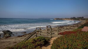 A wooden boardwalk leading to a beach with waves crashing onto the shore.