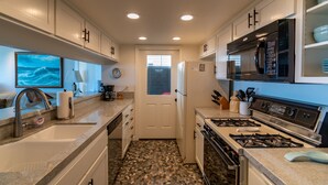 A modern kitchen with granite countertops, stainless steel appliances, and a tiled backsplash.
