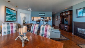 A spacious living room with a wooden dining table, a sofa, and a fireplace.