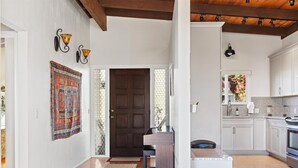 A modern kitchen with white cabinets, a built-in oven, and a countertop. - A Cool House, A Cool View (Cambria)
