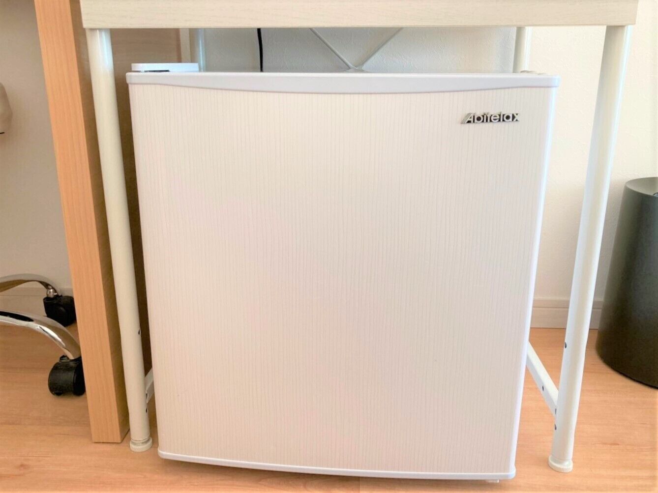 Un refrigerador compacto y blanco, con la marca 'Aptelax' a la vista en la parte frontal.
