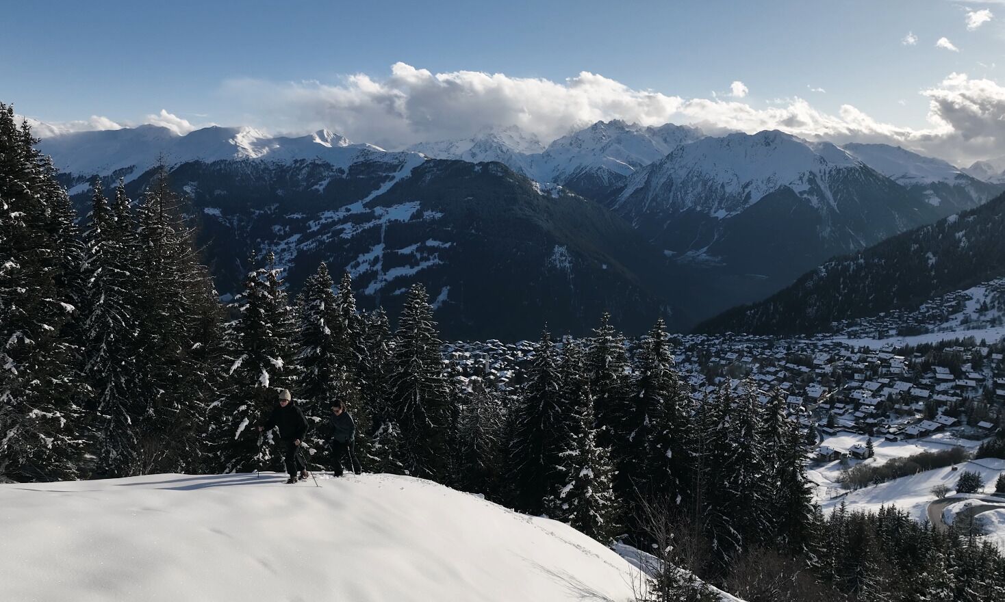 A snowy mountain landscape with a village in the valley.