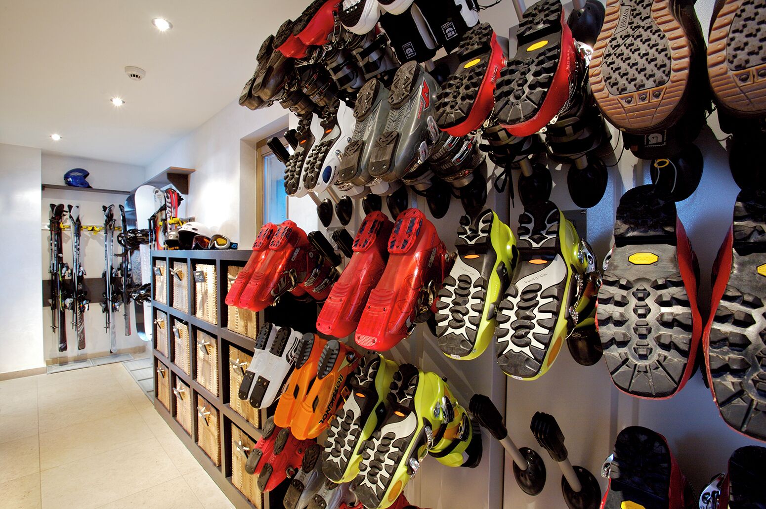 Een schoenenwinkel met verschillende soorten schoenen, tentoongesteld op planken en wanden.