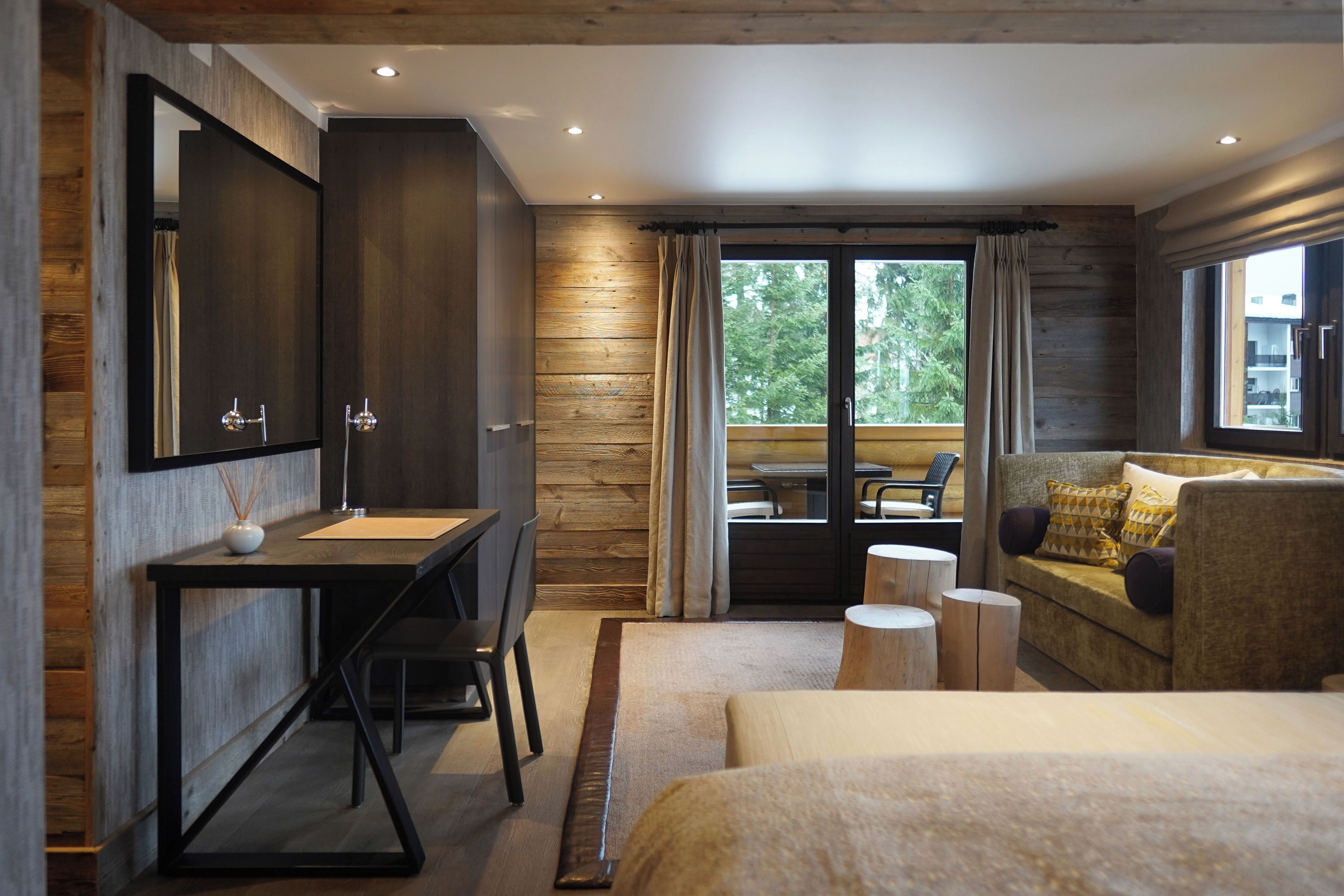 Une chambre moderne avec un grand lit, un bureau avec un miroir et un canapé.