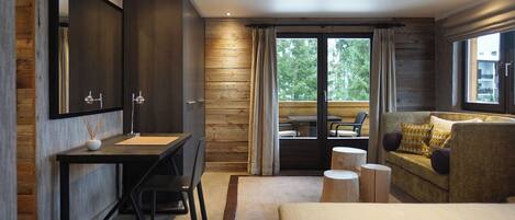 Une chambre moderne avec un grand lit, un bureau avec un miroir et un canapé.