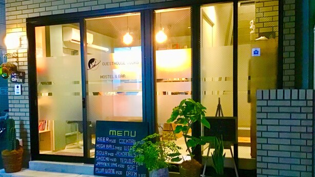 A hostel with a glass front displaying a menu.