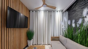 A modern living room with a flat-screen TV, wooden panel walls, a ceiling fan, and a large window with sheer curtains. - Private Balconies w/ Heated Pool, Hot Tub Near French Qtr – Family Friendly (New Orleans)