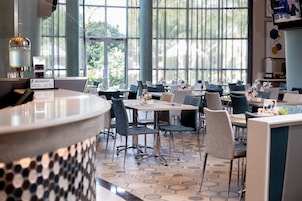 A modern restaurant with a breakfast menu, large windows, and a hexagonal patterned floor.