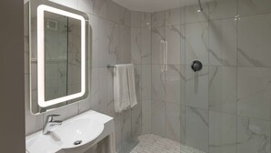 A modern bathroom with a large mirror, a sink, and a shower. - StayEasy Mbombela (Mbombela)