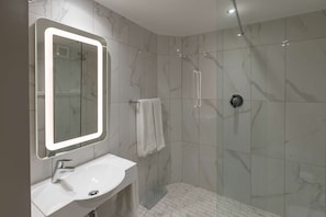 A modern bathroom with a large mirror, a sink, and a shower. - StayEasy Mbombela (Mbombela)