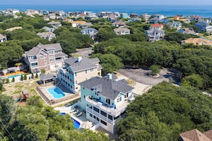 A large residential property with multiple buildings, a swimming pool, and a well-maintained garden.