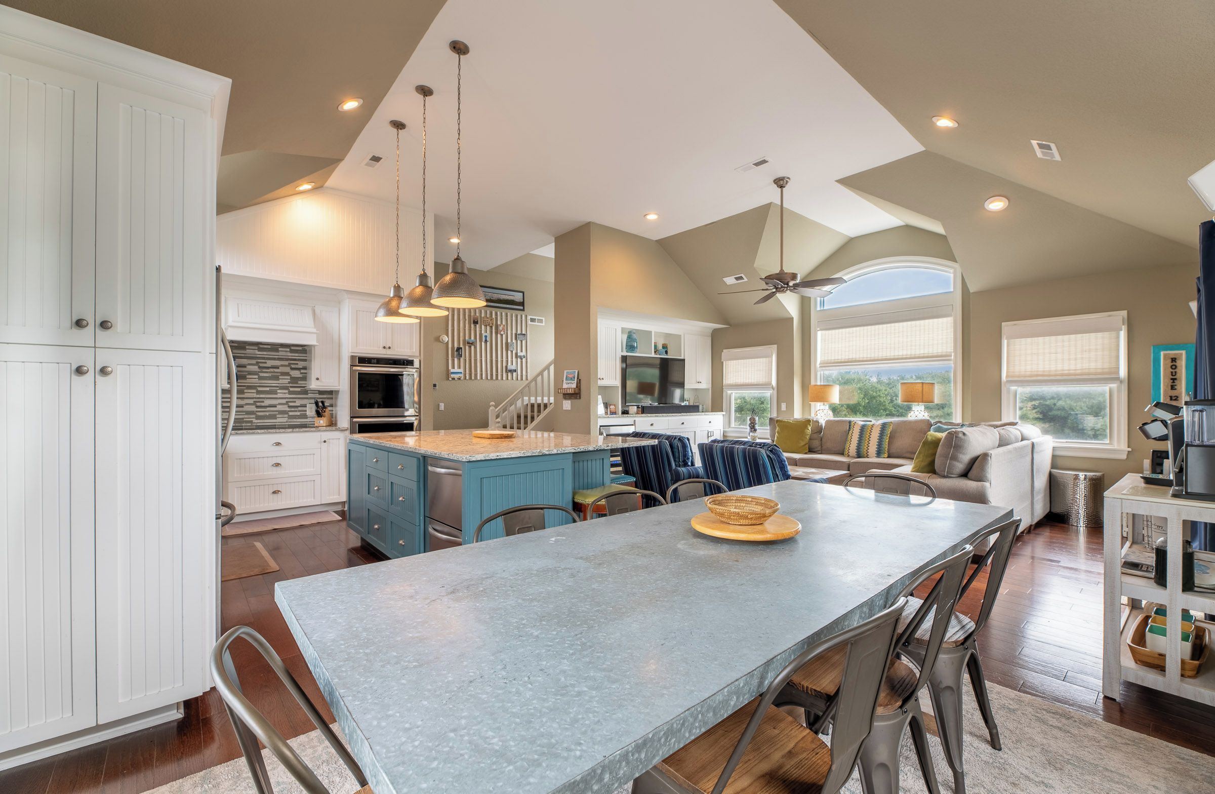 A spacious kitchen with a large island, modern appliances, and pendant lighting.