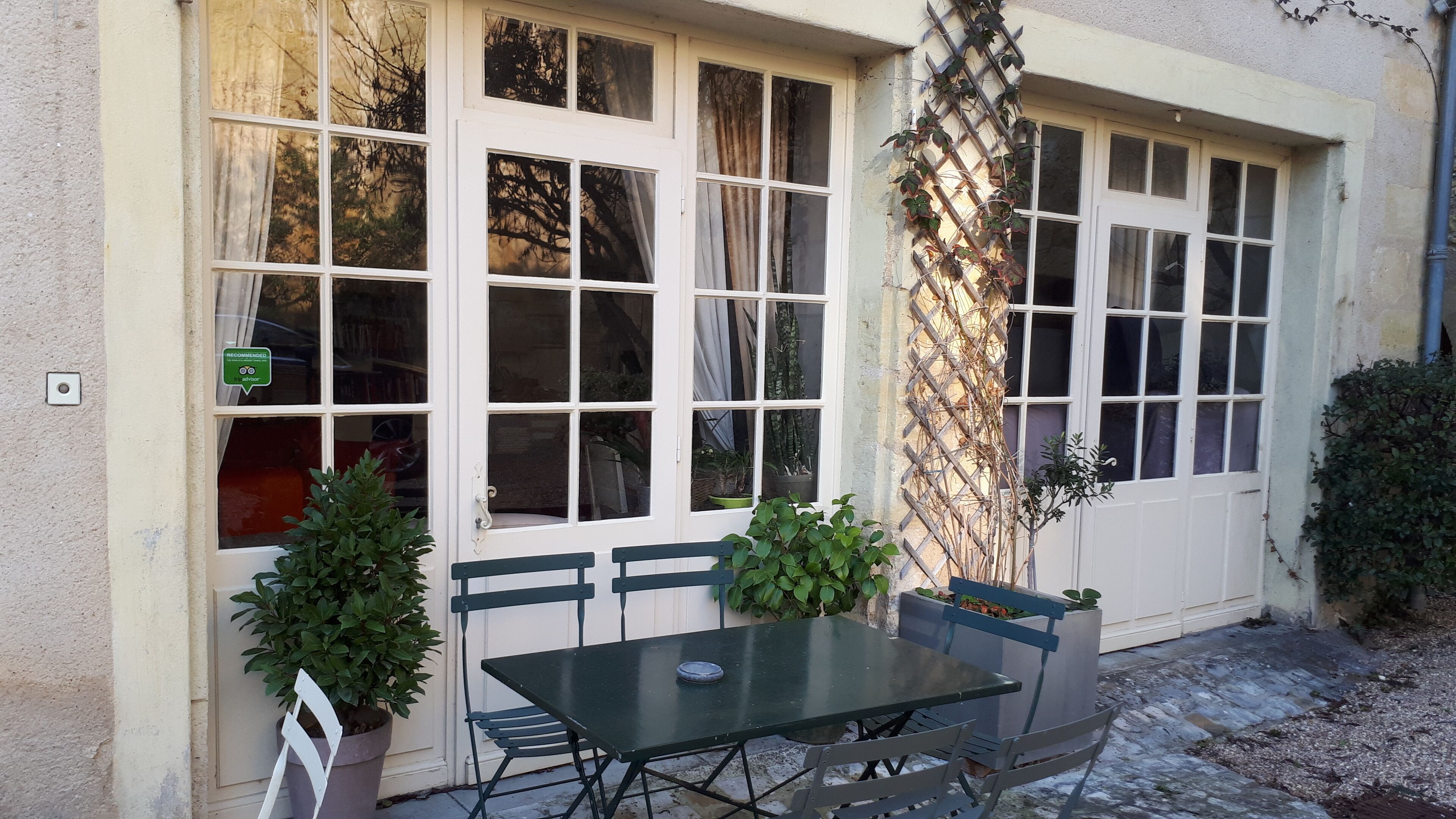 A building with large windows, a table, and chairs outside.
