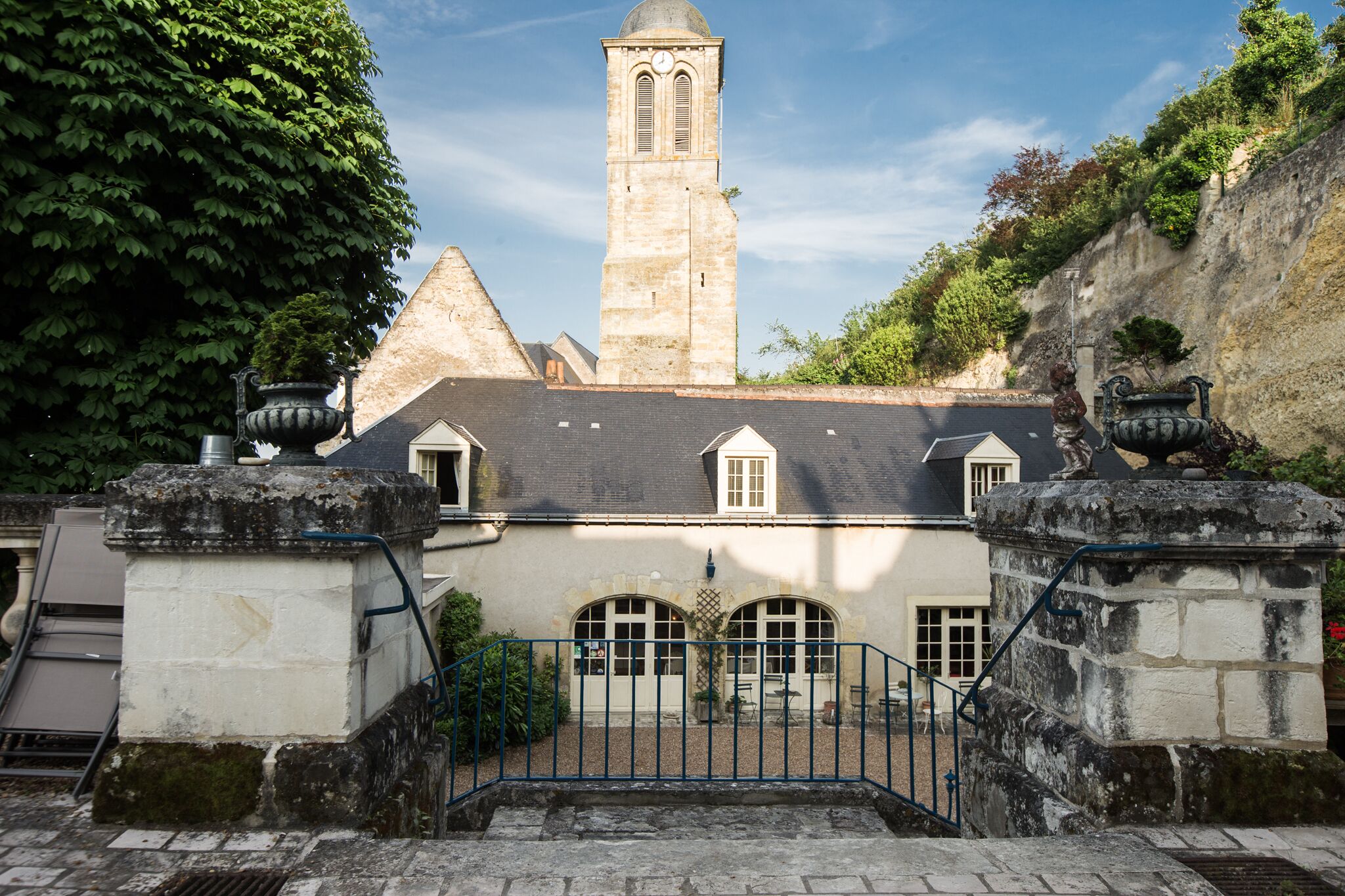 Un edificio histórico con una torre destacada, una entrada porticada y una escalera que conduce a los niveles superiores.