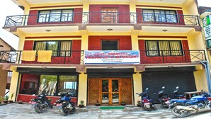 A two-story building with a sign for Hotel Nagarkot Holiday Inn & Restaurant.