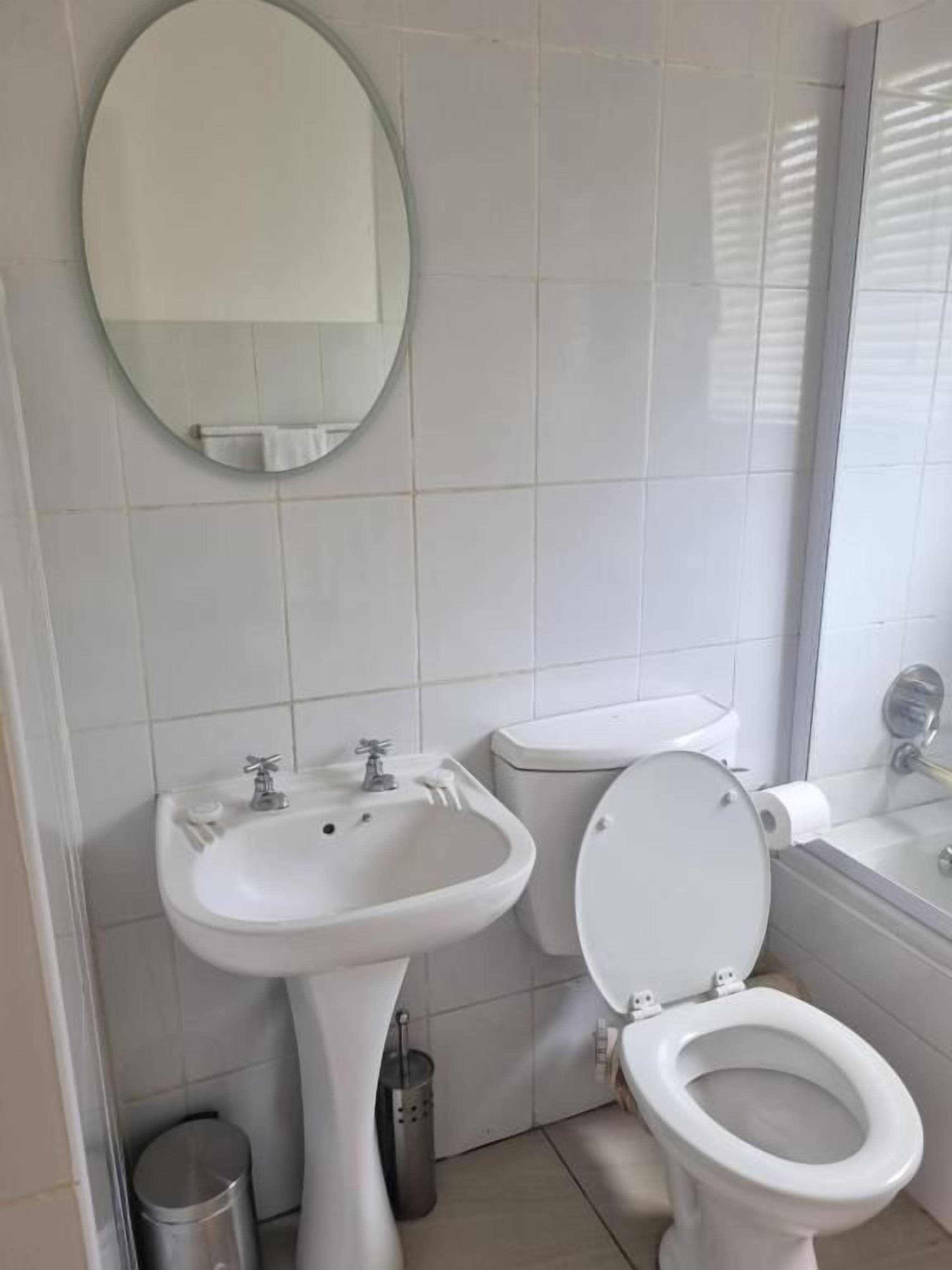 A bathroom with a pedestal sink, toilet, and bathtub.