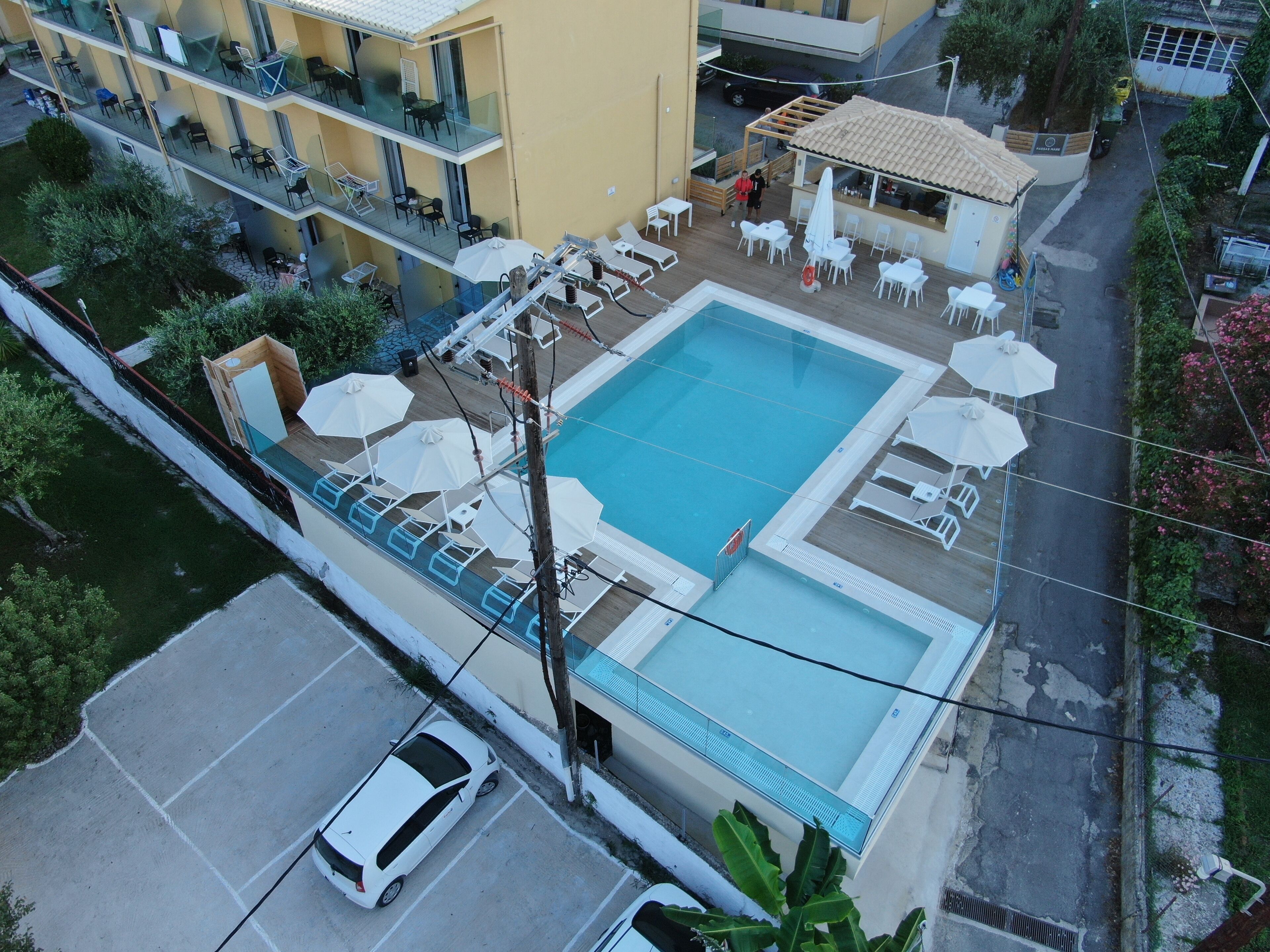 Vista aérea de um hotel com piscina, área de estar externa e um terraço coberto.