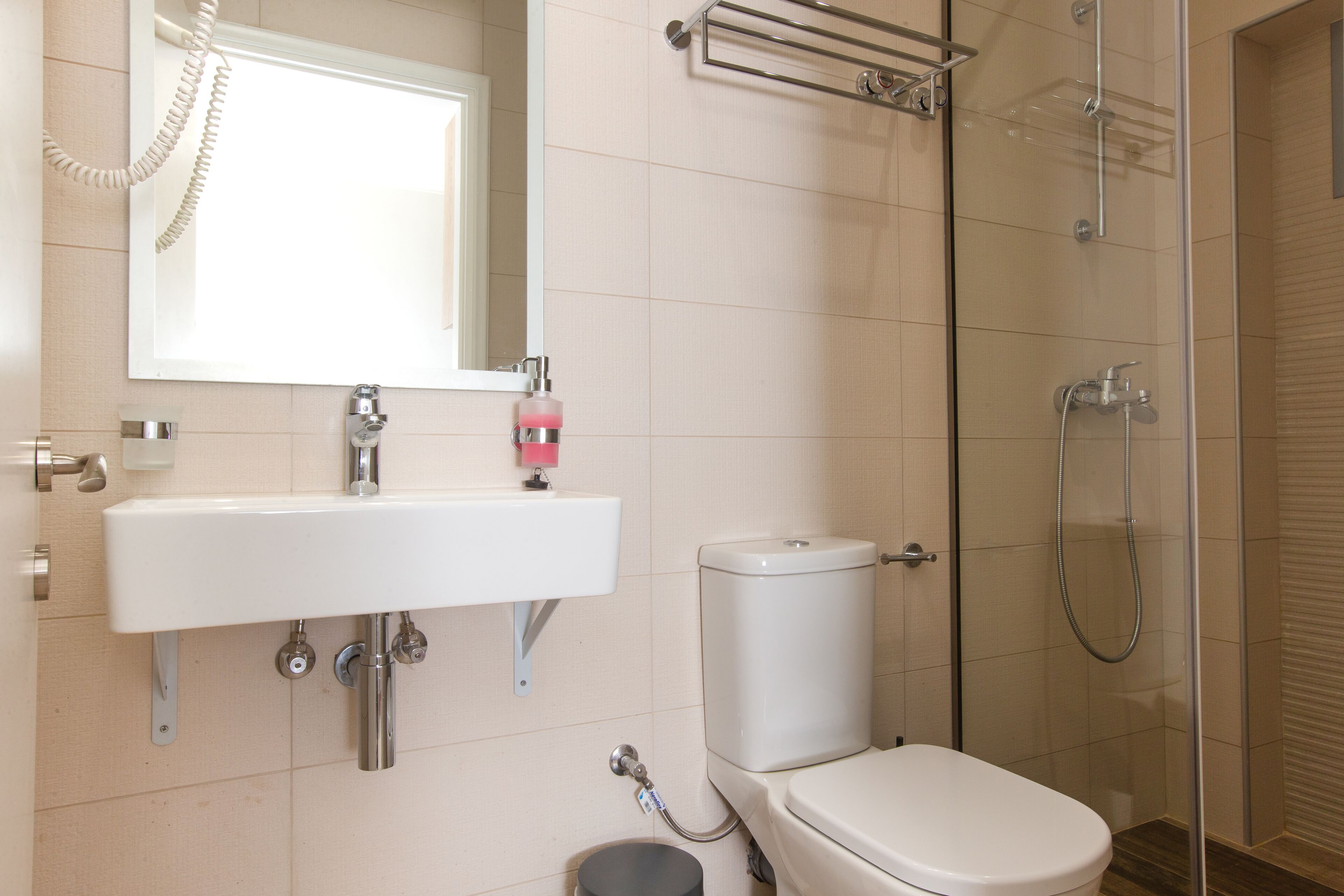 A bathroom with a white sink, a toilet, a shower, and a glass-enclosed shower area.