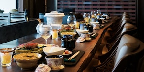 A long dining table with various dishes, glasses, and utensils, suggesting a restaurant setting. - UMITO ATAMI HONTEI　 (Atami)