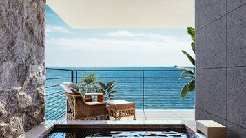 A balcony with wicker furniture overlooking a body of water.