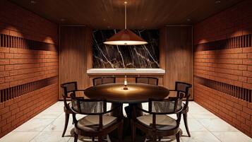 A round dining table with six chairs, a marble backsplash, and a hanging pendant light.