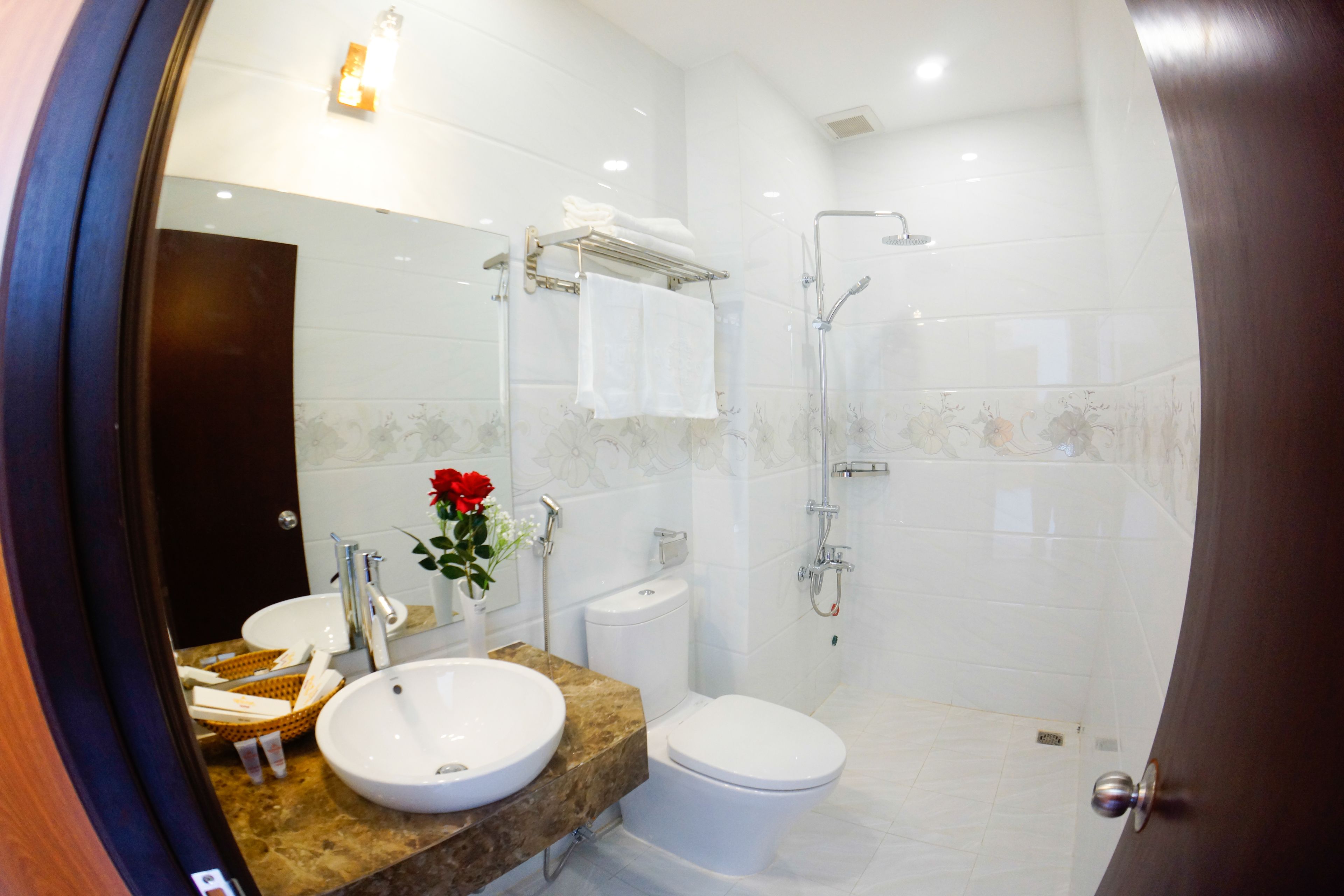 A modern bathroom with a sink, toilet, and shower.