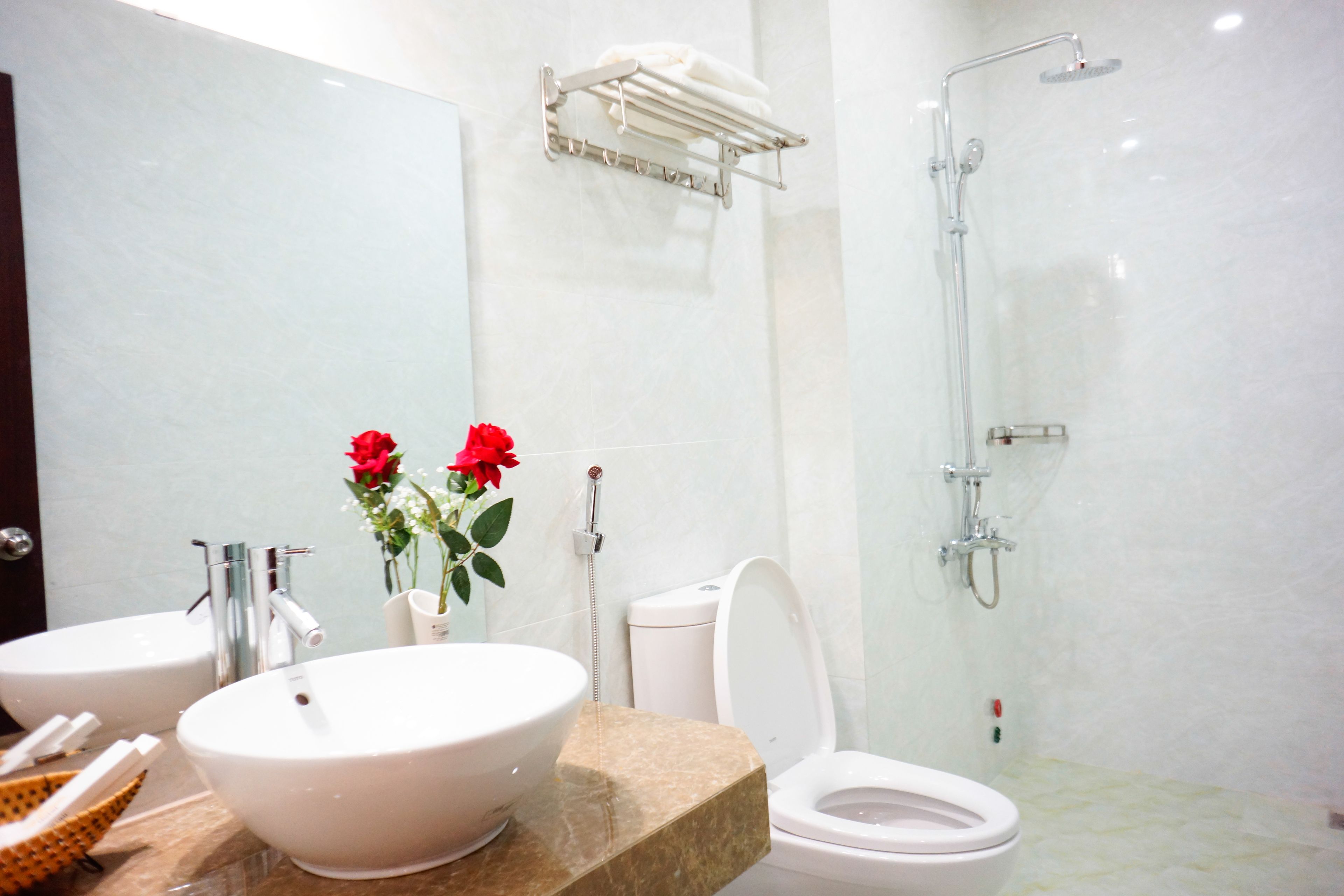 Une salle de bain avec deux lavabos, des toilettes, une douche et un porte-serviettes.
