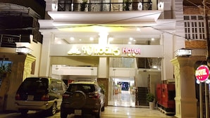 A hotel entrance with a sign reading "Nuno's Hotel" and a "NO ENTRY" sign. There are two cars parked in front. - Nu Hoang Hotel (Phan Rang)