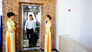 An elevator with marble walls and a number 6 sign. - Nu Hoang Hotel (Phan Rang)