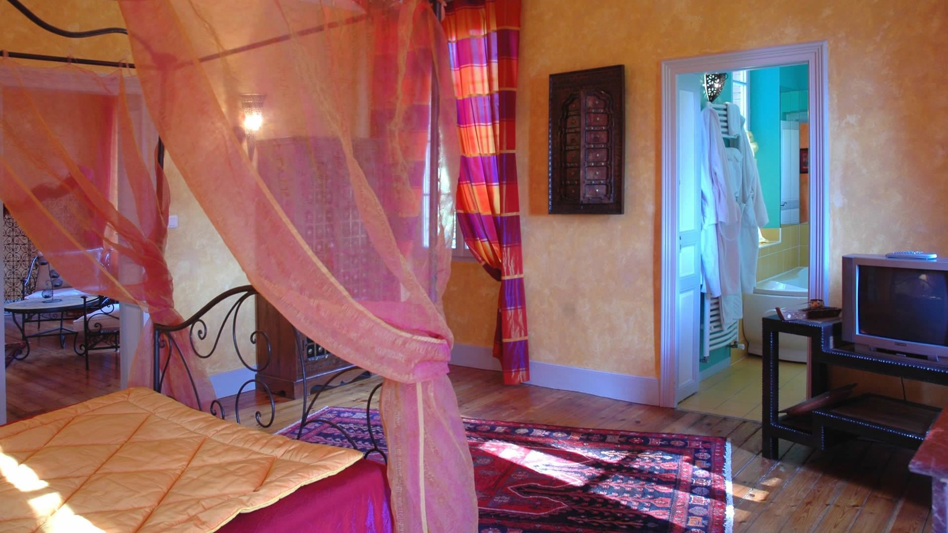 Un dormitorio con cama, televisión, escritorio y silla.