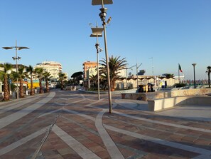 A spacious public square with palm trees, a fountain, and a hotel named "Sole Hotel" in the background. - Hotel Maxim (Misano Adriatico)